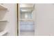 A bathroom with white cabinets, a mirror above the sink and a view from the shelf at 12405 3Rd E St # 306, Treasure Island, FL 33706