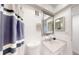 Well-maintained bathroom with vanity, mirror and shower with patterned curtain at 12405 3Rd E St # 306, Treasure Island, FL 33706