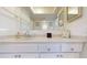 Well-lit bathroom vanity with bright counter tops, neutral colors, and a large mirror at 12405 3Rd E St # 306, Treasure Island, FL 33706