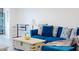Bright living room with a comfy blue sofa, neutral decor, and a glimpse of the water view at 12405 3Rd E St # 306, Treasure Island, FL 33706
