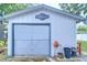 Exterior of Wendy's Workshop featuring a garage door, potted plants, and tool rack at 129 Siobhan Ave, Tampa, FL 33613
