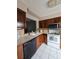 Modern kitchen with wood cabinetry, sleek countertops, white appliances, and a view into the living area at 13813 Mission Oaks Blvd, Seminole, FL 33776