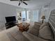 Cozy living room featuring tile floors, neutral walls, comfortable seating, and a view to the bedroom at 13813 Mission Oaks Blvd, Seminole, FL 33776