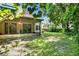 Backyard featuring a screened-in porch, grass, and lush trees at 13902 Bardmoor Pl # B, Tampa, FL 33618