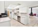 Open concept kitchen with white cabinetry, marble countertops, and view to living room with fireplace at 13902 Bardmoor Pl # B, Tampa, FL 33618