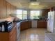 Well-lit kitchen with wooden cabinets, tile flooring, stainless steel appliances, and a double window over the sink at 1425 Corner Oaks Dr, Brandon, FL 33510