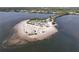 Aerial view of a sandy island with palm trees, parking area, and a land bridge connecting it to the mainland at 1500 Sunset Rd # C7, Tarpon Springs, FL 34689