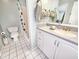 Full bathroom featuring a shower, vanity, mirror, and white tile flooring at 1500 Sunset Rd # C7, Tarpon Springs, FL 34689