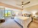 Comfortable bedroom featuring a ceiling fan, plush carpet, and ample natural light from the window at 1500 Sunset Rd # C7, Tarpon Springs, FL 34689