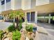 Building entrance with landscaped garden and covered parking at 1500 Sunset Rd # C7, Tarpon Springs, FL 34689