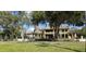 Beautiful multi-story home with mature trees, a manicured lawn, and a stately fence at 1500 Sunset Rd # C7, Tarpon Springs, FL 34689
