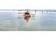 Personal kayaking in clear water with a sandy beach and other boats visible in the background, promoting an active lifestyle at 1500 Sunset Rd # C7, Tarpon Springs, FL 34689