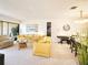 Open living area with comfortable yellow seating, complemented by a dining area with a piano at 1500 Sunset Rd # C7, Tarpon Springs, FL 34689