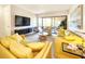 Bright living room featuring plush yellow sofas, stylish seating, and sliding glass doors to the lanai at 1500 Sunset Rd # C7, Tarpon Springs, FL 34689