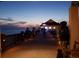 Evening scene on a pier featuring people strolling and a musician playing, with a serene waterfront view at 1500 Sunset Rd # C7, Tarpon Springs, FL 34689