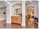 Hallway with hardwood floors, a wooden console table, a large mirror, and a view of adjacent rooms at 15305 Fishhawk Preserve Dr, Lithia, FL 33547