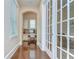 Hallway featuring hardwood floors, built-in desk area, and french doors to living space at 15305 Fishhawk Preserve Dr, Lithia, FL 33547