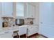 This home office features custom cabinetry, granite countertops, a mosaic tile backsplash and natural light at 15305 Fishhawk Preserve Dr, Lithia, FL 33547
