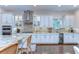 This kitchen boasts stainless steel appliances, granite countertops, white cabinets, and a wine refrigerator at 15305 Fishhawk Preserve Dr, Lithia, FL 33547