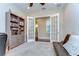 Home office offers french doors, hardwood floors, a ceiling fan, and built-in shelving at 15305 Fishhawk Preserve Dr, Lithia, FL 33547