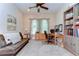 Bright home office features a ceiling fan, built-in shelving, a desk, and a comfortable couch at 15305 Fishhawk Preserve Dr, Lithia, FL 33547