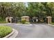 Gated community entrance with stone pillars, black iron gates, and mature trees at 16621 Kingletside Ct, Lithia, FL 33547