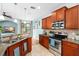 Modern kitchen with stainless steel appliances, granite countertops, and dark wood cabinetry at 16621 Kingletside Ct, Lithia, FL 33547