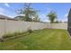 Well maintained backyard with vibrant green grass, white fence, and a garden area at 19926 Stone Pine Cir, Lutz, FL 33558