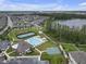 Aerial shot of a community with a pool, tennis courts, basketball court, playground, and scenic pond at 19926 Stone Pine Cir, Lutz, FL 33558