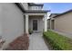 Charming home entrance featuring a covered porch, stone walkway, and well-manicured landscaping at 19926 Stone Pine Cir, Lutz, FL 33558