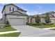 Two-story gray home with a two-car garage and paved driveway; includes well-maintained landscaping at 19926 Stone Pine Cir, Lutz, FL 33558
