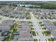 Overhead shot of a neighborhood featuring well-maintained houses, green spaces, and a nearby lake at 19926 Stone Pine Cir, Lutz, FL 33558