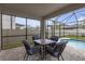Covered patio featuring a table and chairs and view of screened pool at 19926 Stone Pine Cir, Lutz, FL 33558