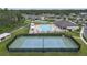 Aerial view of tennis courts, a pool, and clubhouse within a gated community at 19926 Stone Pine Cir, Lutz, FL 33558