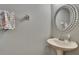 Stylish half-bathroom features a modern mirror, a pedestal sink and a lovely floral towel at 20537 Lace Cascade Rd, Land O Lakes, FL 34637