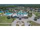 A bird's eye view of a clubhouse, fountain, and sparkling community pool surrounded by lush landscaping and palm trees at 20537 Lace Cascade Rd, Land O Lakes, FL 34637