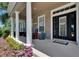 Inviting front porch with white columns, rocking chairs, and a welcoming entrance, enhanced by colorful flowers at 20537 Lace Cascade Rd, Land O Lakes, FL 34637