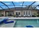 A luxurious screened pool area with comfortable seating, spa, and lush landscaping, perfect for relaxation and entertainment at 20537 Lace Cascade Rd, Land O Lakes, FL 34637