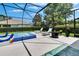 Relaxing screened-in pool area with chaise lounges, a fire pit, and a tiled spa, ideal for outdoor leisure and entertaining at 20537 Lace Cascade Rd, Land O Lakes, FL 34637