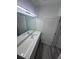 Bathroom features a granite countertop, dual sinks, large mirror, and wood-look vinyl floors at 2108 E 22Nd Ave # 1, Tampa, FL 33605