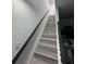 Modern staircase features gray wood stairs, white walls, and black handrail at 2108 E 22Nd Ave # 1, Tampa, FL 33605