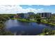 Scenic view of the condominium complex and its community pool, set by a serene lake at 220 Belleview Blvd # 104, Belleair, FL 33756
