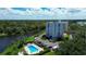 Scenic aerial view of a building with a pool and lush landscaping, offering a picturesque setting and community amenities at 220 Belleview Blvd # 104, Belleair, FL 33756