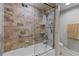 Beautiful bathroom with a glass enclosed shower, stone walls, and modern fixtures at 220 Belleview Blvd # 104, Belleair, FL 33756
