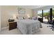 Inviting bedroom featuring a view of a covered balcony and comfortable furnishings at 220 Belleview Blvd # 104, Belleair, FL 33756