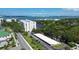 Scenic view of building surrounded by lush landscaping and a peaceful pond, offering a serene waterfront living experience at 220 Belleview Blvd # 104, Belleair, FL 33756
