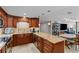 Open kitchen features wood cabinetry, granite counters, stainless appliances, and opens to a dining and living area at 220 Belleview Blvd # 104, Belleair, FL 33756