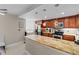 Kitchen with granite countertops, stainless steel appliances, and wooden cabinets with decorative hanging lights at 220 Belleview Blvd # 104, Belleair, FL 33756