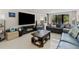 Cozy living room featuring comfortable seating, a large TV, fireplace, and natural light from the large window at 220 Belleview Blvd # 104, Belleair, FL 33756