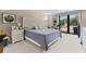Bright bedroom featuring a decorative headboard, neutral decor, carpeted floors, and access to a balcony at 220 Belleview Blvd # 104, Belleair, FL 33756